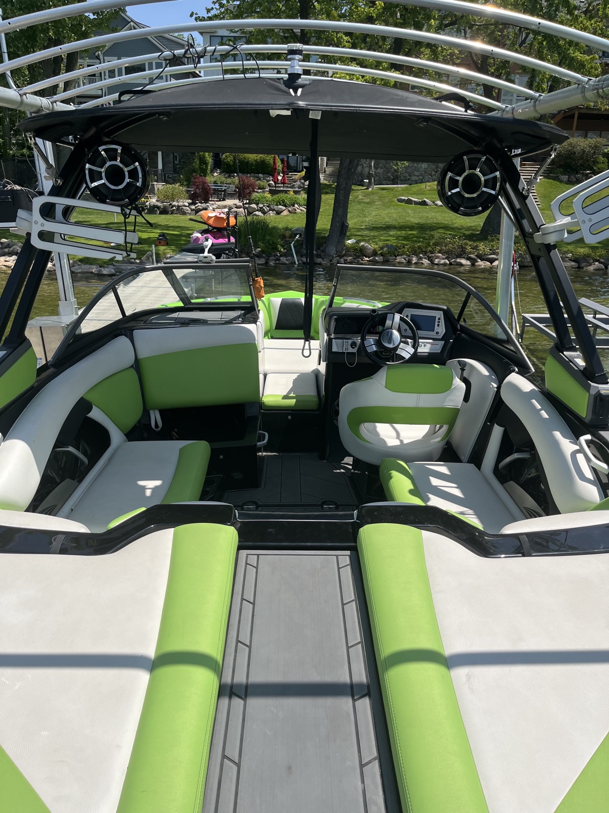 Vibrant green and white Malibu wakeboard boat interior detailed on the lake