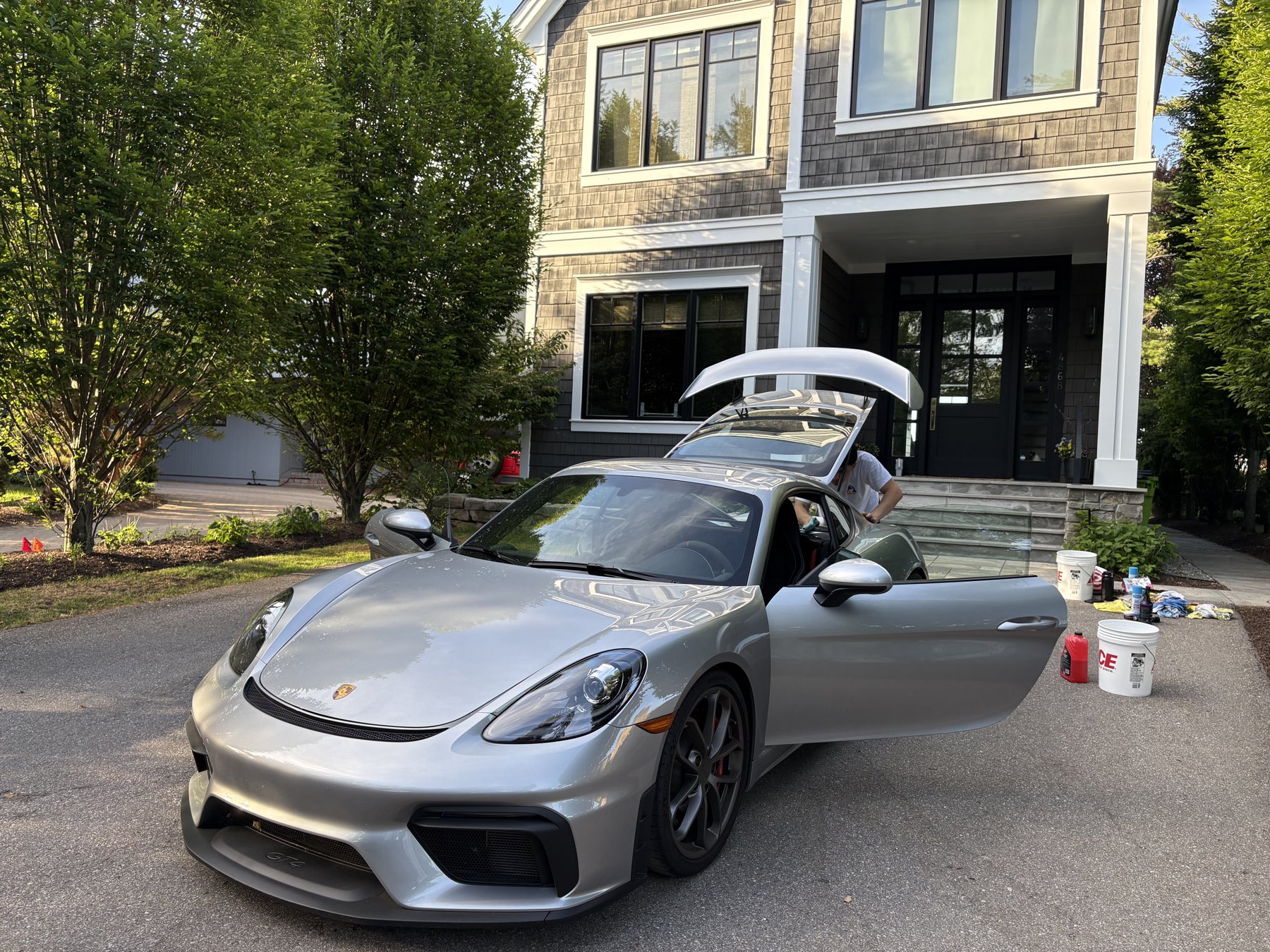 AL Luxury detailing a silver Porsche in a Metro Detroit driveway